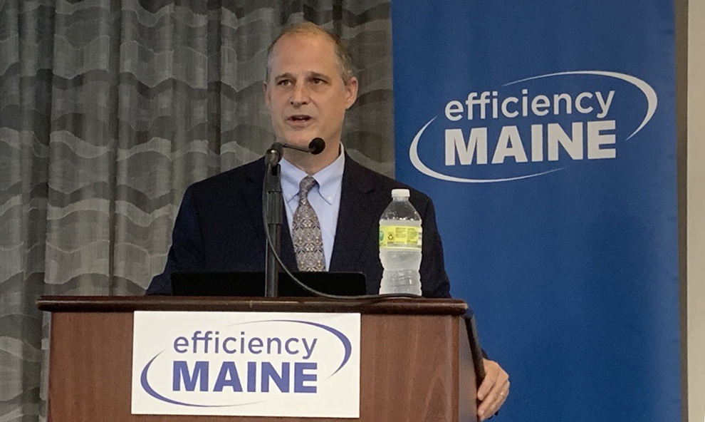 Efficiency Maine Executive Director Michael Stoddard speaking at a podium.