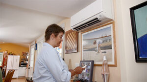Woman operating a heat pump with a remote control.
