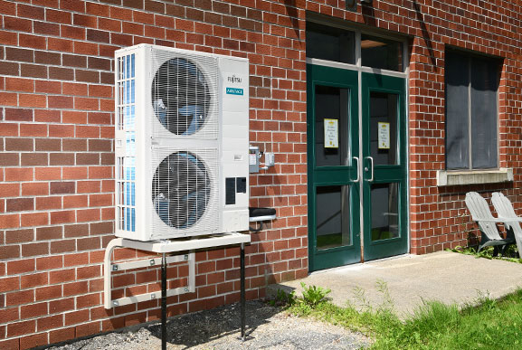 Heat pump outdoor units outside a small business or school.