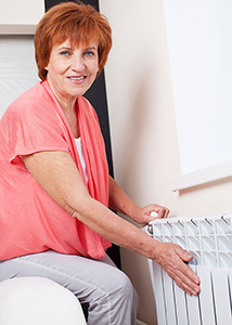 Woman feeling a radiator to check for heat.