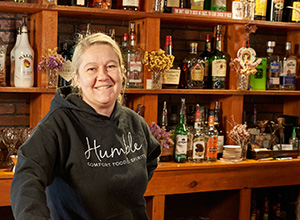 Woman standing in front of bar rack.