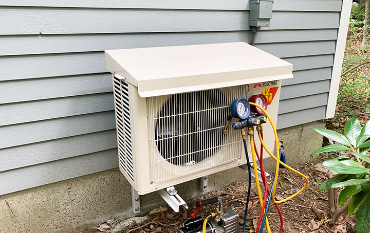 A heat pump mounted to the side of a home.